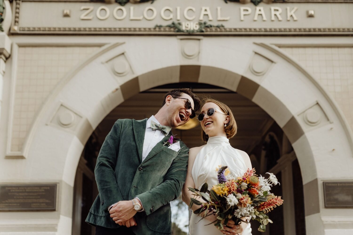 A couple laughing under the Zoological Park arch at Taronga Zoo